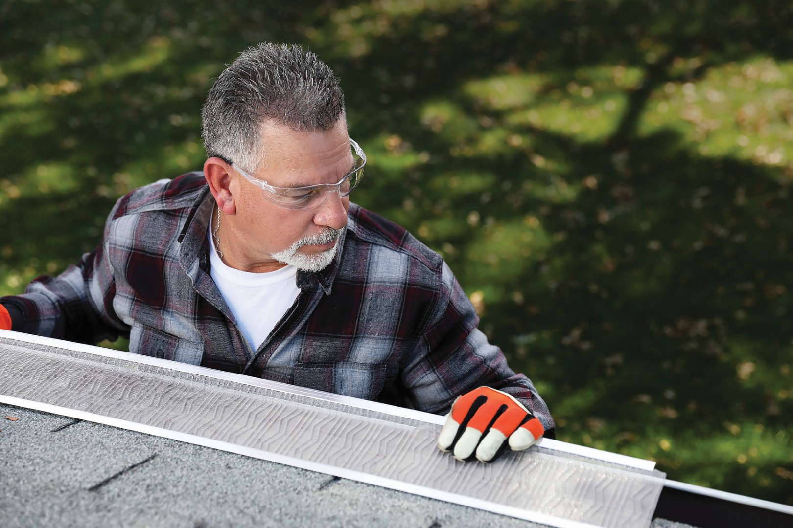man installing leaf blaster gutter guards